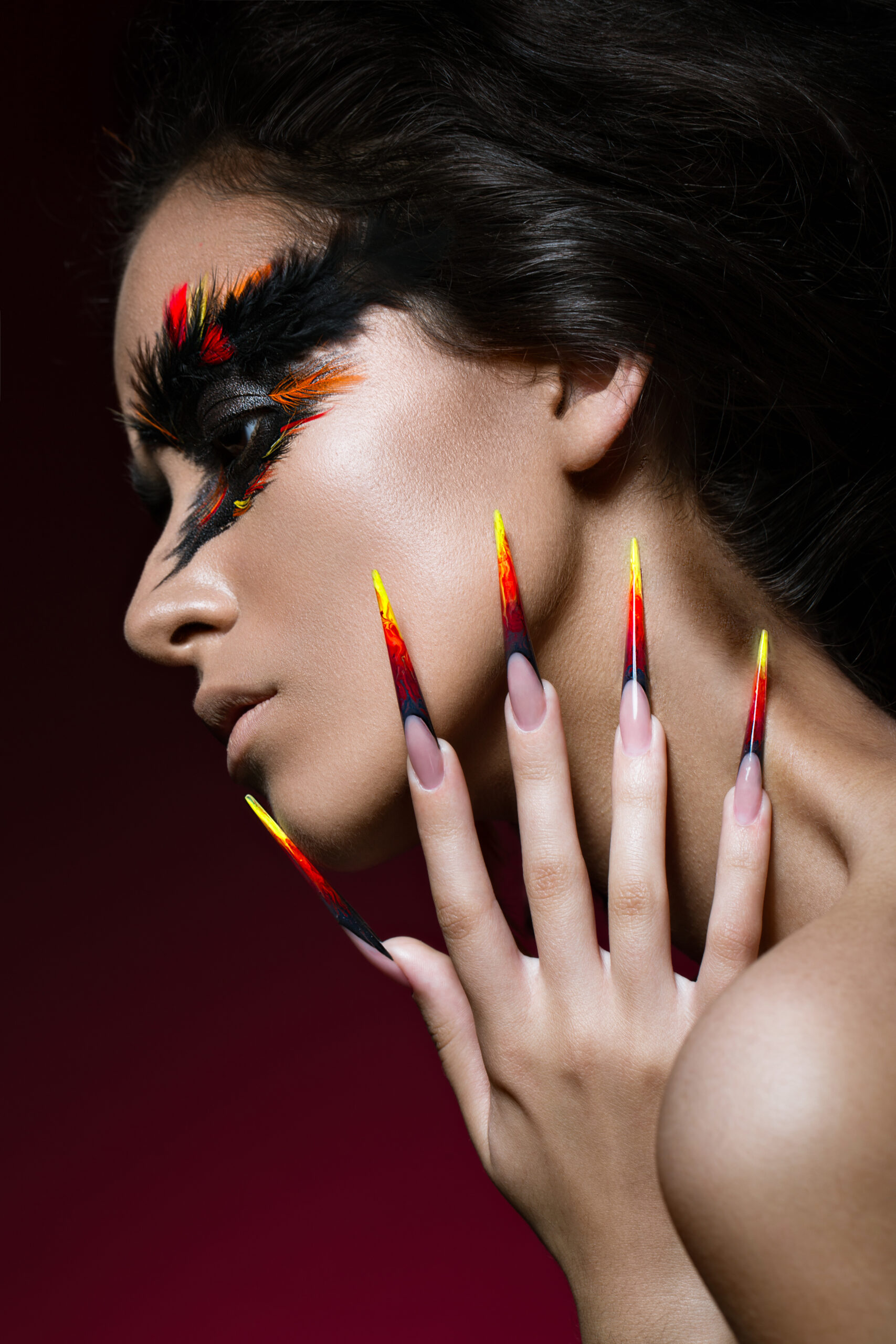Beautiful girl in image of Phoenix bird with creative makeup and long nails. Manicure design. beauty face.